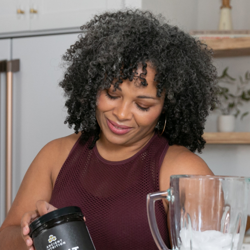 woman adding bone broth to a smoothie