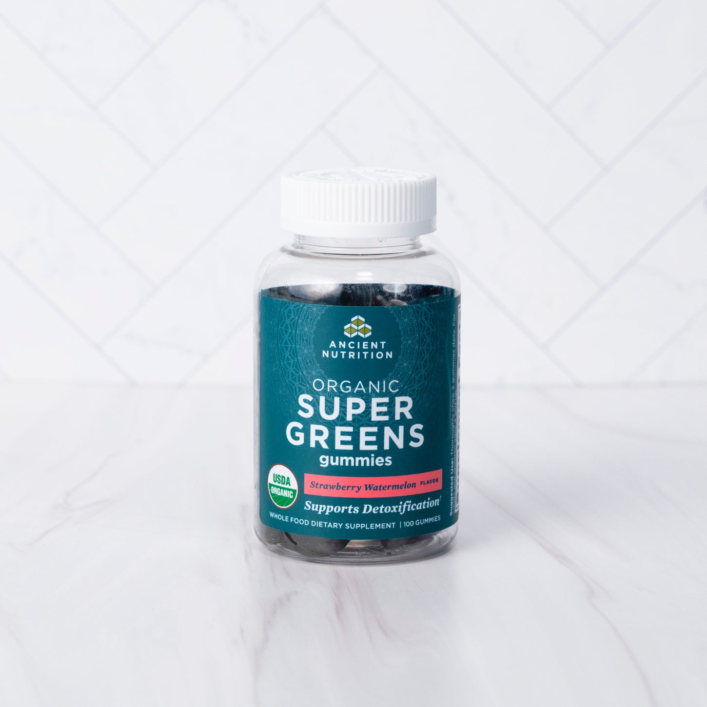 Organic Super Greens Gummies Strawberry Watermelon Flavor on a marble background