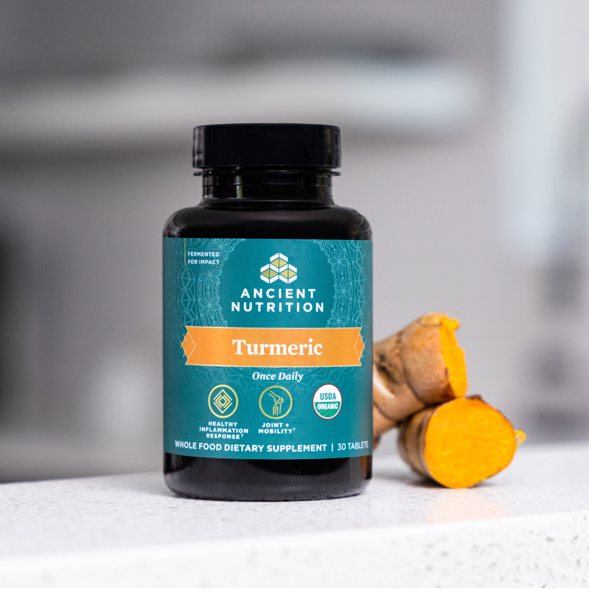 Organic Turmeric Tablets bottle next to turmeric root