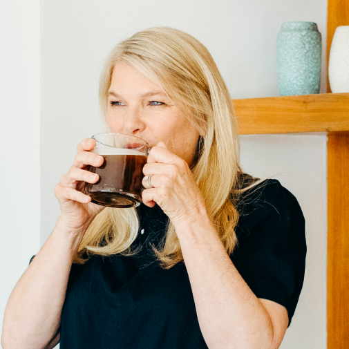 woman drinking coffee from a glass mug