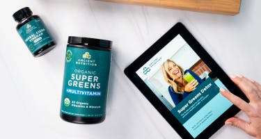 bottle of supergreens next to an ipad