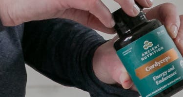 Woman holding cordyceps capsules